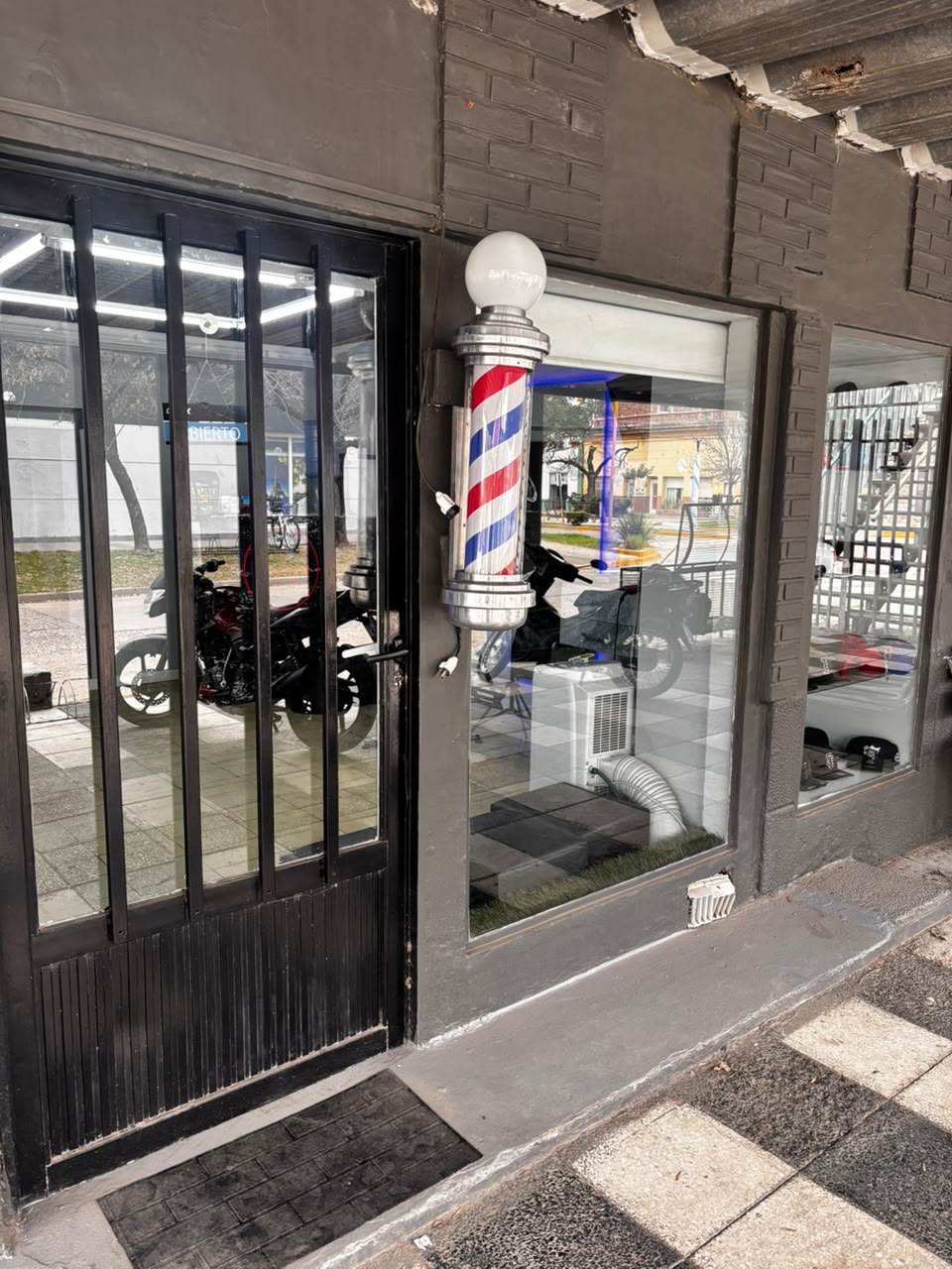 Entrada de Navajas con el poste de barbería iluminado