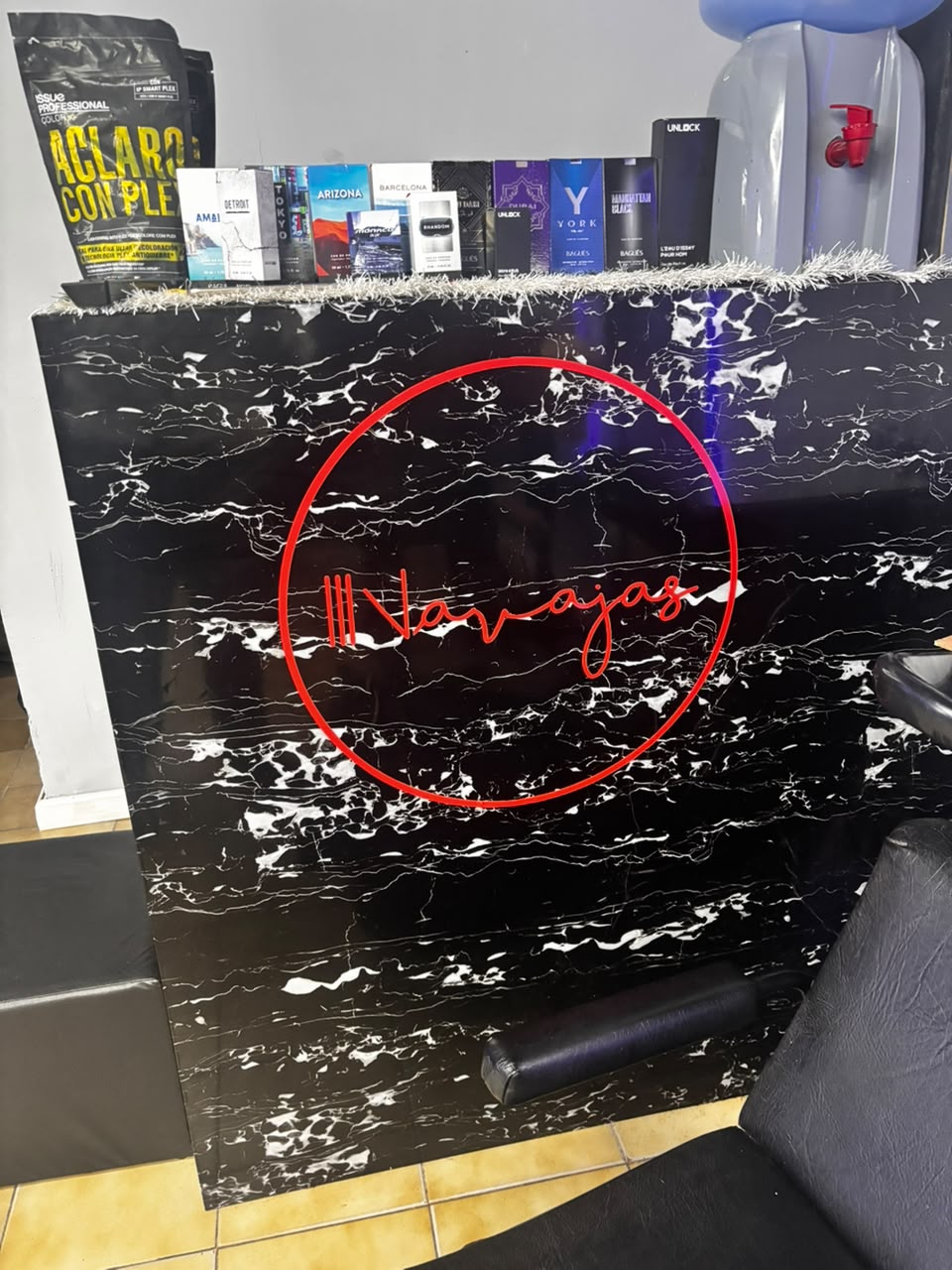 Mostrador de atención con perfumes y el logo de Navajas en neón rojo