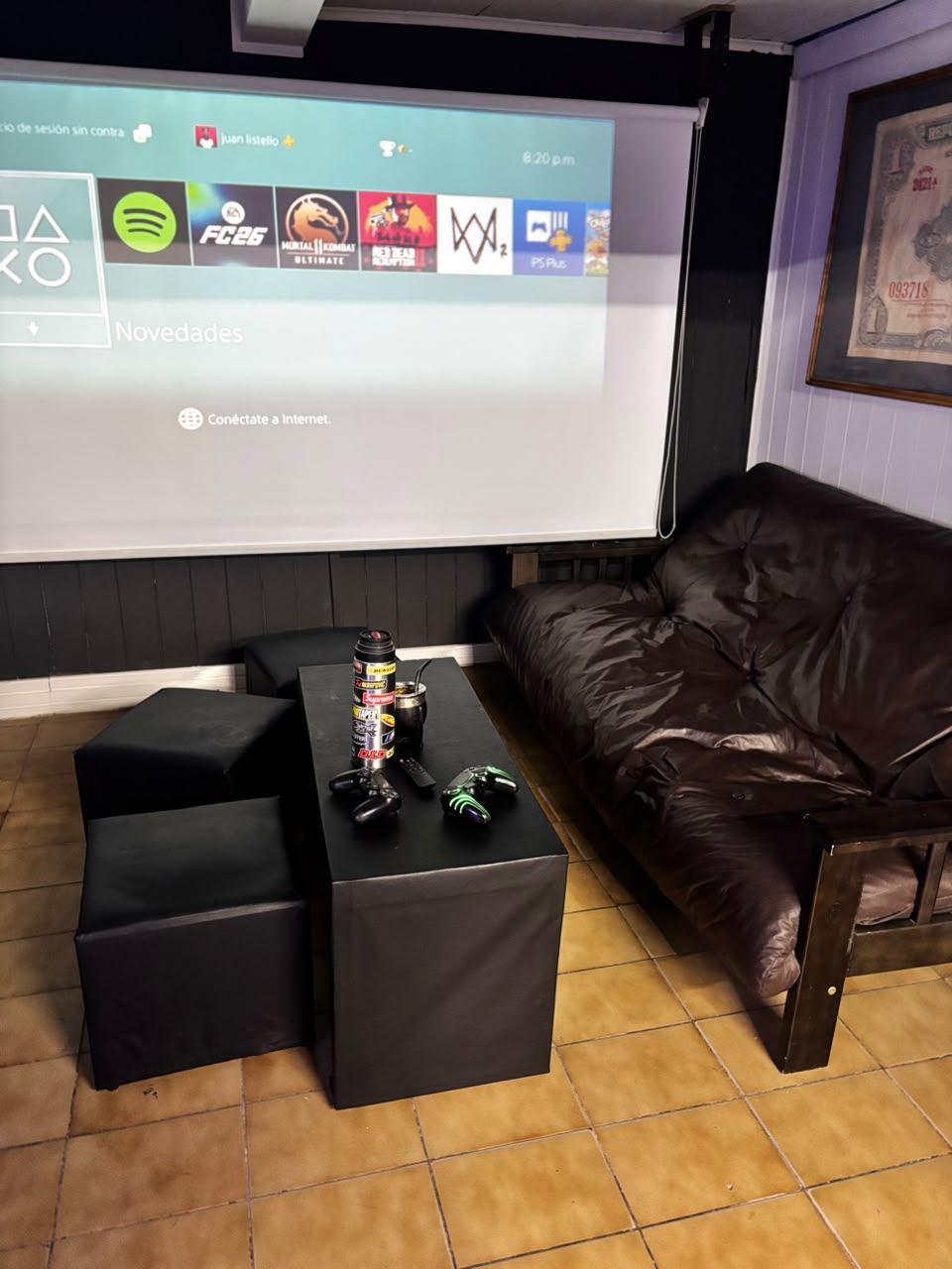 Sillón de cuero y pufs frente al proyector en la sala de espera